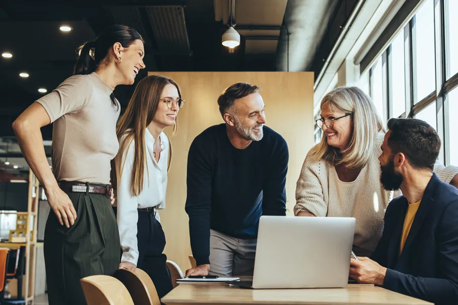 A group of colleagues smiling at each other in an office