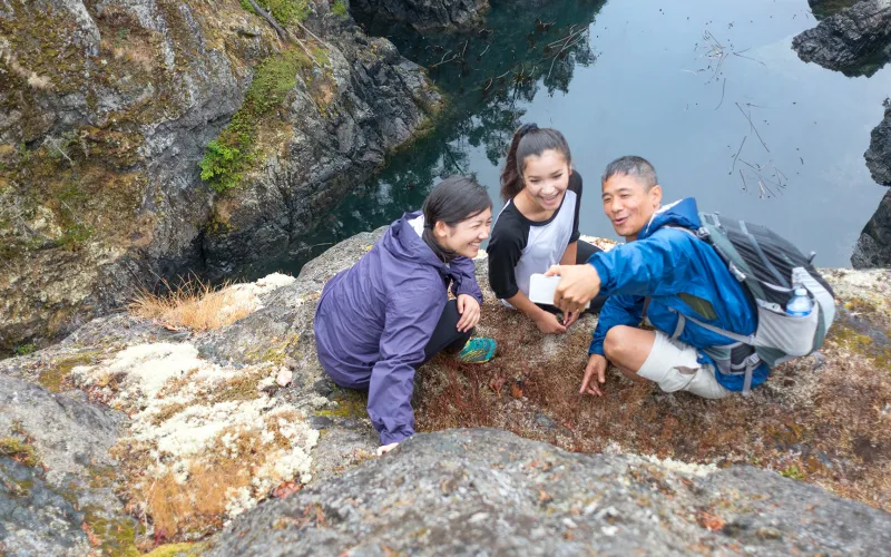 Family taking selfie on a rock