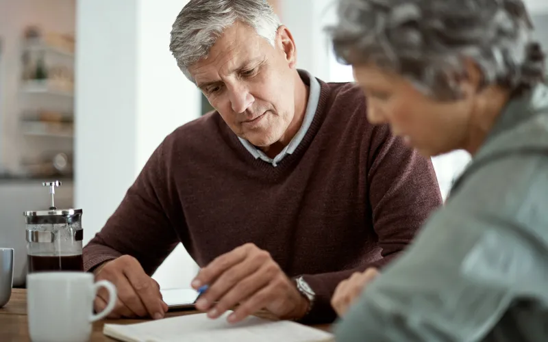 Older couple planning at kitchen table