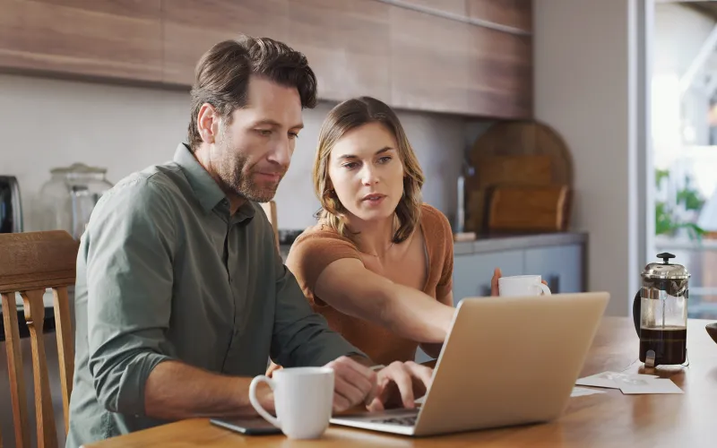Couple in home doing research on laptop