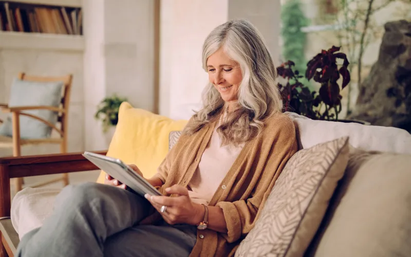 Woman looking at her tablet on the sofa