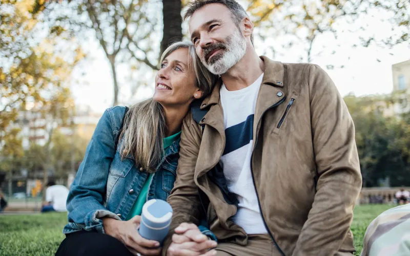 A couple sitting outside together in a park.