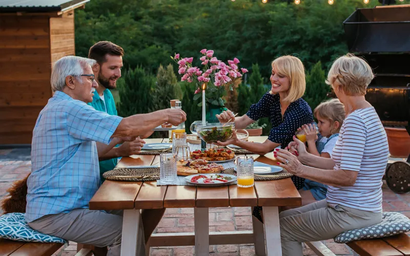 A family eating a meal together outside.