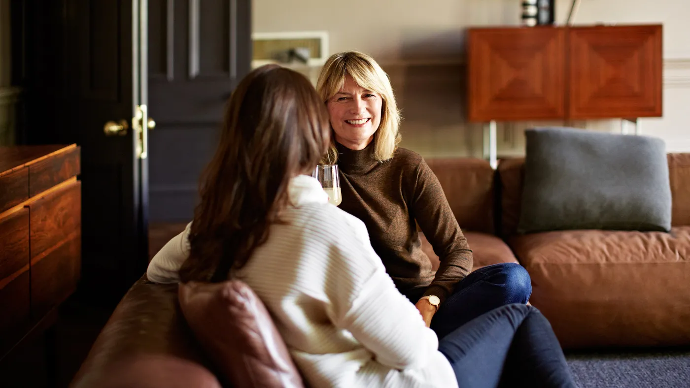 Two older woman talking on a couch