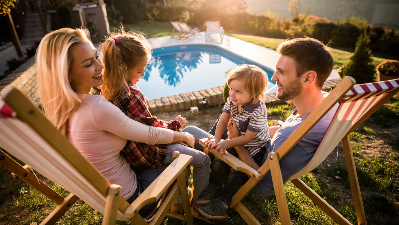 Family on holiday sitting by pool