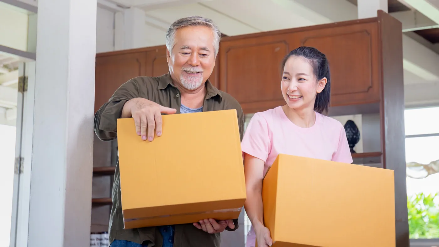 Father and daughter carrying boxes