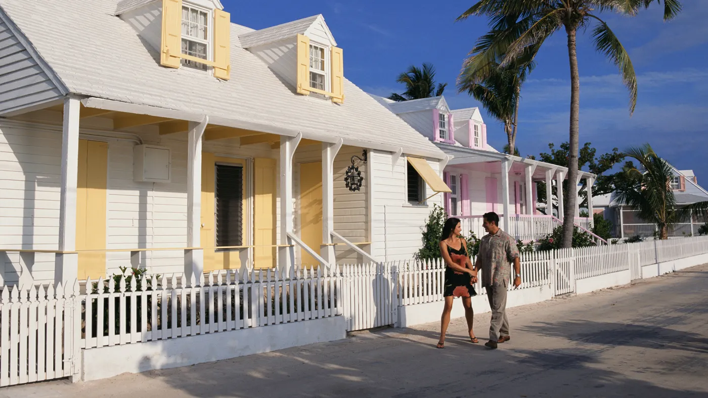 Couple walking on street with bright character homes