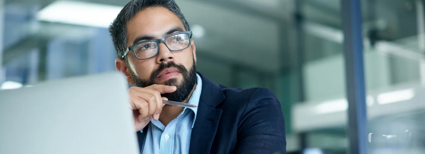 Man thinking in front of laptop