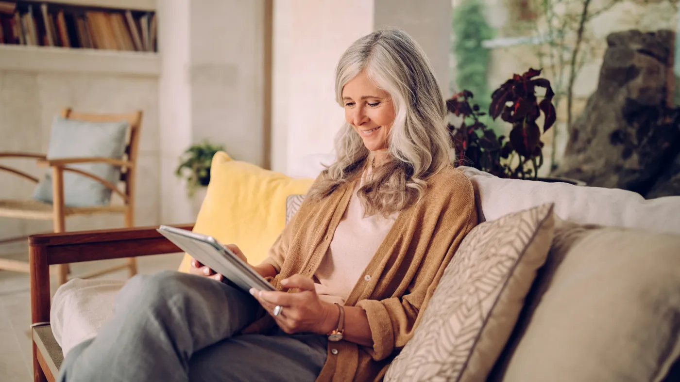 Woman looking at her tablet on the sofa