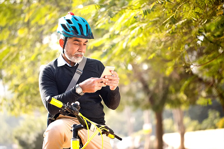 A man looking at his phone while out for a bike ride.