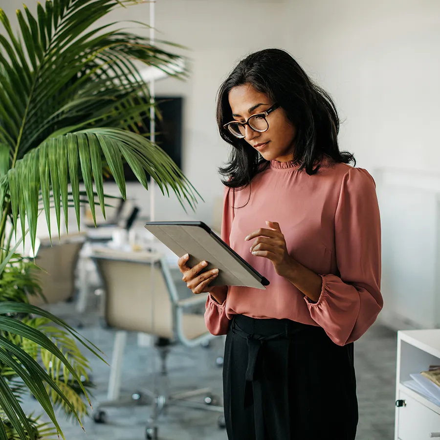 A woman looking at a tablet in an office