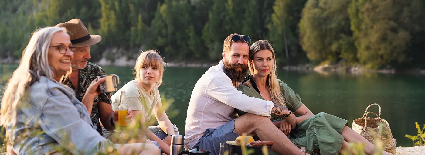 A family sitting with each other beside a lake.